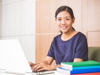 Young asian businesswoman working on laptop at office during, smiling and happy working.