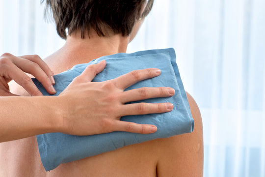 Physiotherapie Kompresse wird zur Schmerzlinderung an die Schulter gehalten