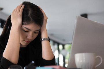 Fototapeta premium tired businesswoman with hand on head at office. frustrated young woman with headache at workplace. exhausted startup in depression after long work. overwork, stress, fatigue concept