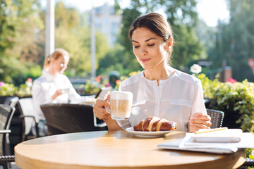 Pretty young woman drinking latte in cafe