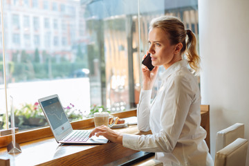 Young businesswoman talking on the phone in cafe