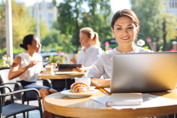 Smiling woman working on her project in cafe