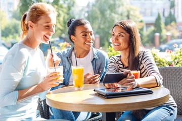 Three friends taking a selfie together in cafe