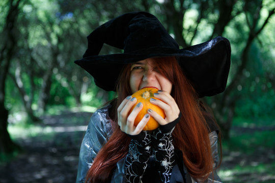 Image of witch biting pumpkin