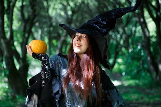 Picture of cheerful witch in hat with pumpkin