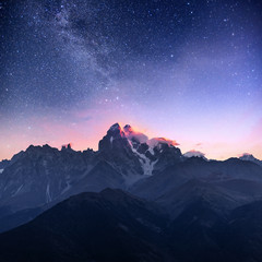 Fantastic starry sky. Autumn landscape and snow-capped peaks. Main Caucasian Ridge. Mountain View from Mount Ushba Meyer, Georgia. Europe