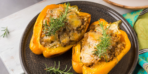 Bell peppers stuffed with barley and meat baked on gray. Complex lunch with vegetables, cereal and meat