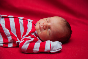 newborn baby sleeping on a red background