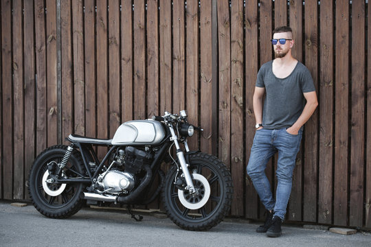 Rider guy with classic style cafe racer motorcycle