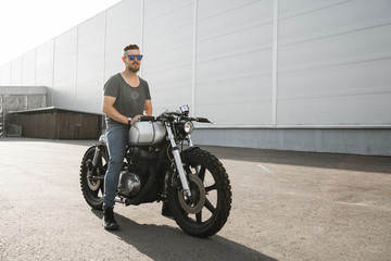 Rider guy with classic style cafe racer motorcycle