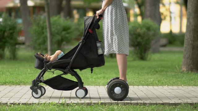Mother with baby carriage drives on gyroscooter