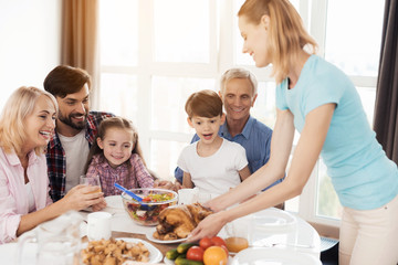 A woman serves a baked turkey for dinner on Thanksgiving Day.