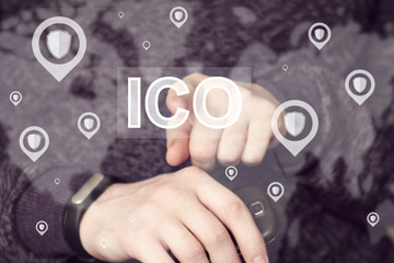 Initial Coin Offering (ICO). Businessman presses button ICO Initial Coin Offering in network shield...