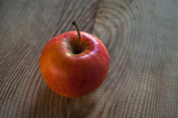 Ripe red apple on rustic dark wooden table