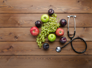 Naklejka na ściany i meble Diet concept with medical stethoscope and fresh fruits