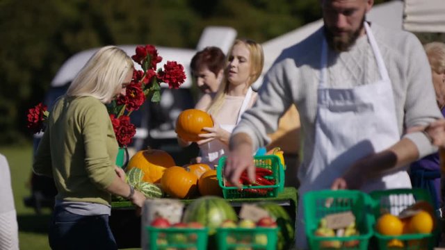  Friendly stall holders selling to customers at the farmers market.
