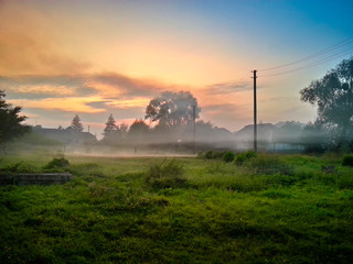 Beautiful morning countryside landscape with soft fog before sunrise