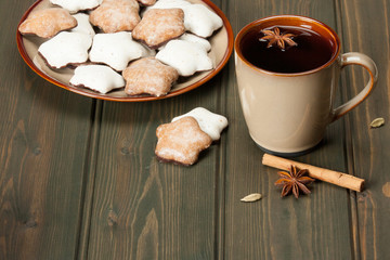 Mug Of Tea Or Coffee. Spices. Gingerbread Star Cookies With Icing. Wooden Background With Copy Space