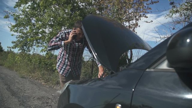 There is smoke from the hood of the car. The driver calls the help desk