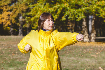 Naklejka premium Mature pretty woman to exercise in a forest glade
