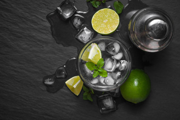 Mojito cocktail with lime and mint in glass on a grey stone background