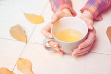 Woman hands holding a cup of green tea. Autumn