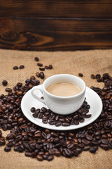 Coffee cup and beans on a rustic background