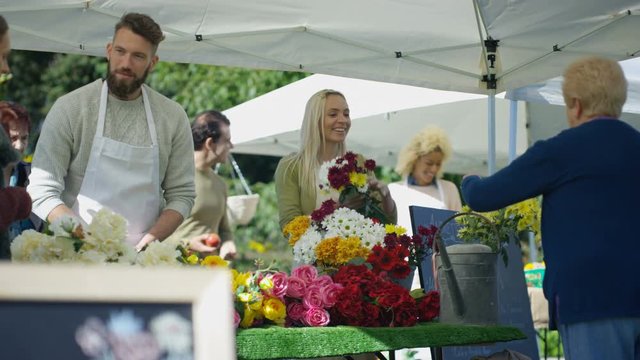  Cheerful customers buying fresh flowers at outdoor summer market