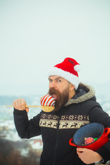 Obraz premium Santa man eating xmas balls on snowy landscape