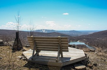 bench on the top of a hill looking at bromont, quebec, canada