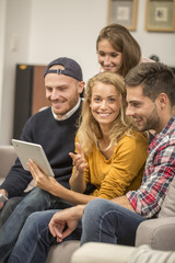 roommates choosing tv program on digital tablet