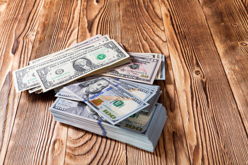 a purse with the American dollars is isolated on a wooden background