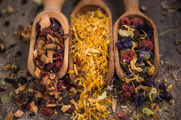 Assorted loose aromatic herbal tea on wooden spoons