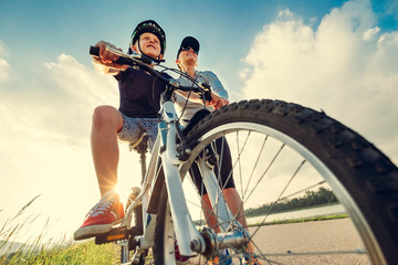 Mother helps her little son start to ride a bicycle
