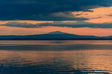 Fototapeta premium sunset over the transylvania lake in Umbria Italy intense late summer colors in the pier