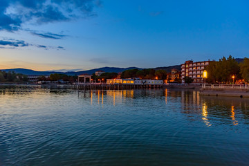 Fototapeta na wymiar sunset over the transylvania lake in Umbria Italy intense late summer colors in the pier