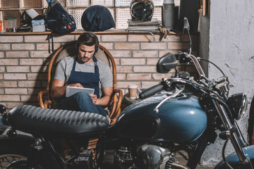 automechanic with tablet in repair shop