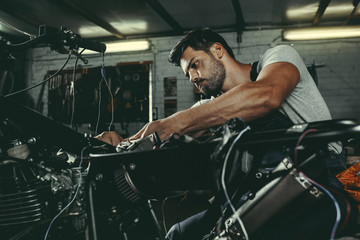 Fototapeta na wymiar handsome mechanic repairing motorbike