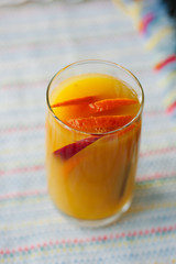 Mango and orange smoothie in transparent glass.