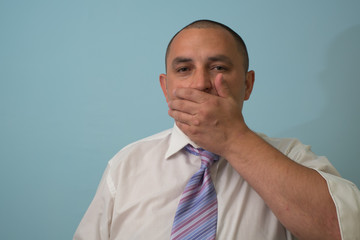 man covers his mouth with his hands, fear, does not want to roar, laughing