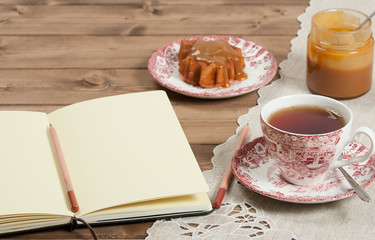 Open Notepad. Homebaked Cake, Maple Leaf Shape. Cup Of Tea. Toffee Sauce. Top View.