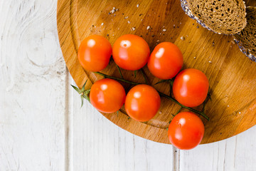 Bunch of cherry tomatoes over wooden board.