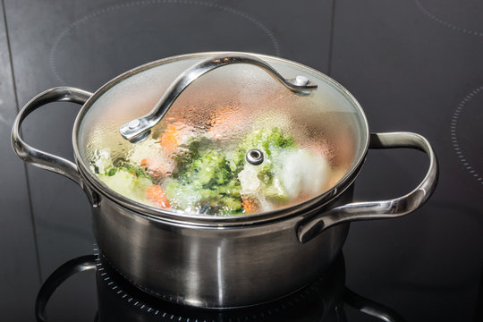 Gem&uuml;se kochen in einem Topf  mit Deckel