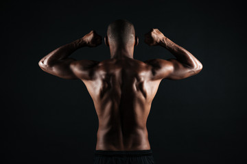 Fototapeta na wymiar Portrait of young afro american sports man, standing back, showing musculs