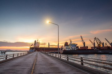 congestion of general cargo sea port terminal working carry on of loading and discharing operation at sunset scenery in background