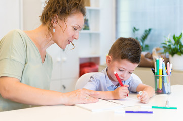 teacher woman drawing with child boy in a classroom