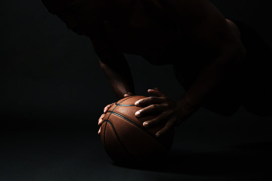 Cropped photo of afro american basketball player,  doing pushup exercise on the ball