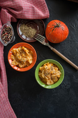 Pumpkin creamy mac and cheese baked pasta over black stone background. Comfort food.