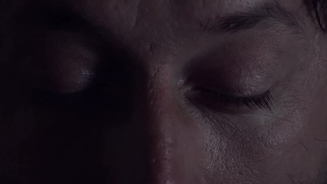 Man having nightmare, close up of male eyes opening after bad dream at night in bed