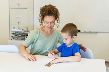 teacher woman learn to use ruler to preschooler boy in the classroom